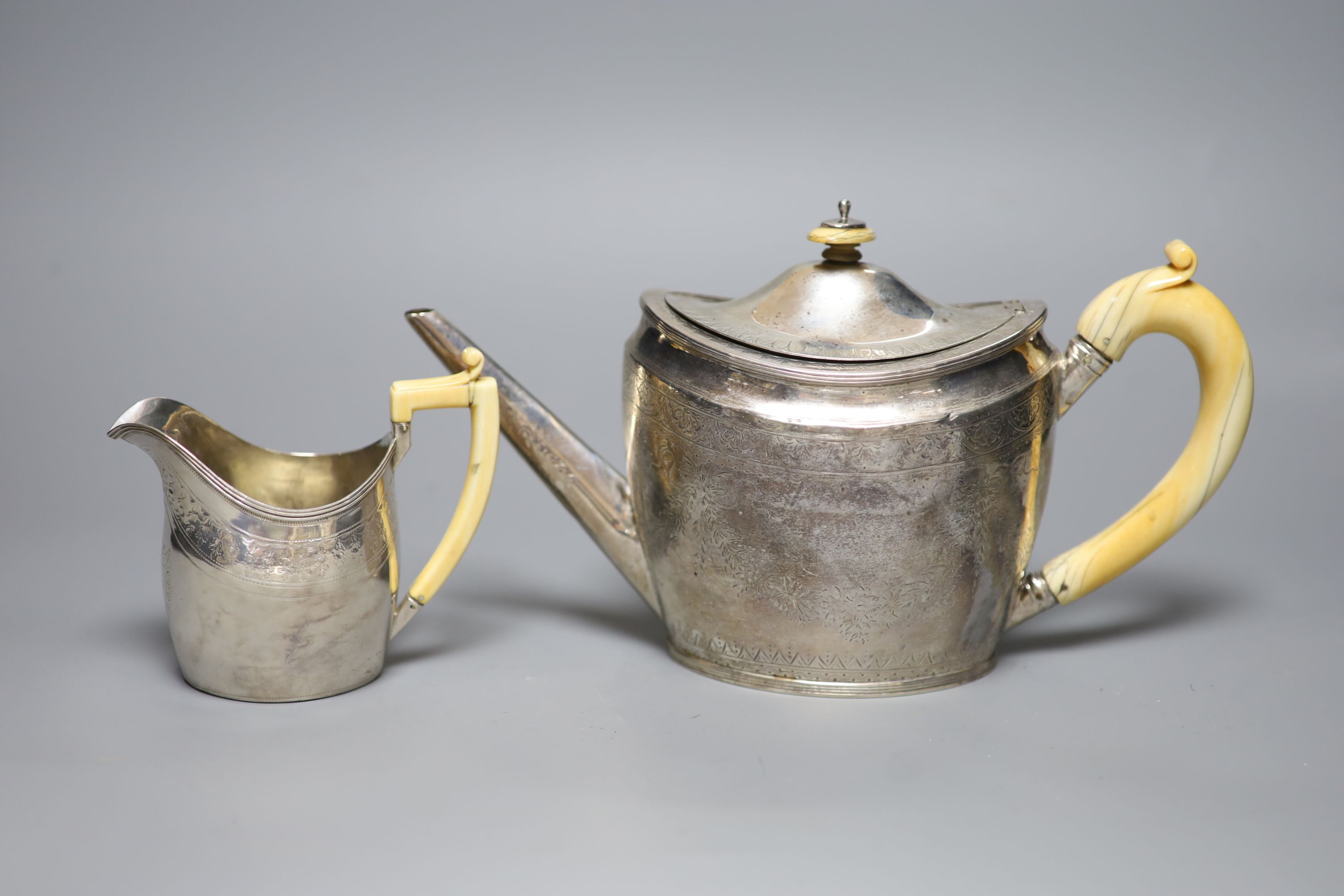 A George III silver teapot, with ivory handle, Henry Green, London, 1795 and a similar cream jug, London, 1796, (a.f.)